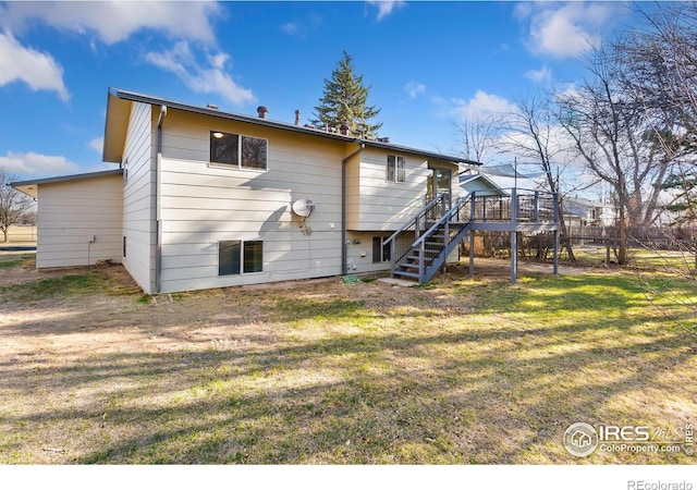 back of property featuring a yard, fence, a deck, and stairs