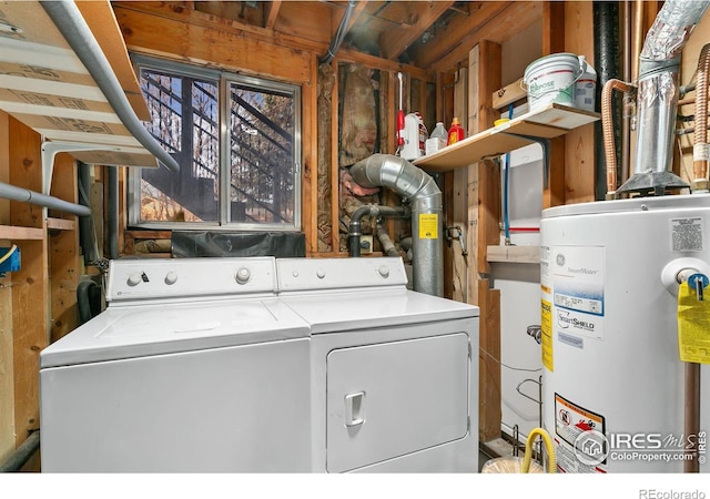 washroom featuring gas water heater, washing machine and dryer, and laundry area