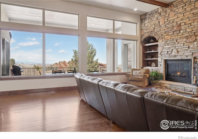 living room featuring a fireplace, recessed lighting, and wood finished floors