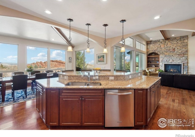kitchen with a kitchen island with sink, dark wood finished floors, open floor plan, beamed ceiling, and stainless steel dishwasher