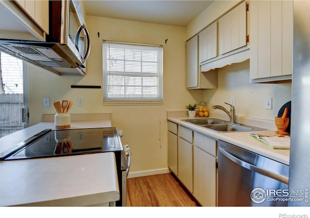 1865 Terry St Unit 3, Longmont, CO 80501 - kitchen with light countertops, a sink, stainless steel appliances, and light wood-style floors