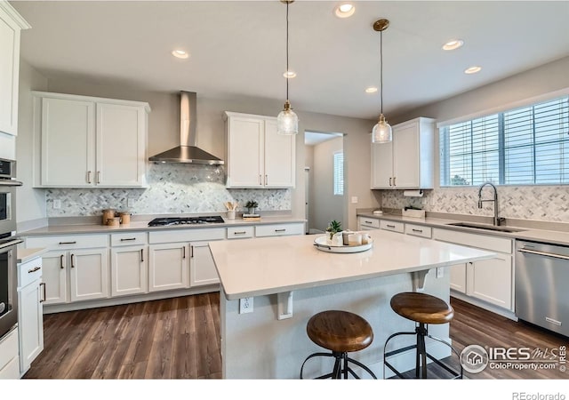 38 Morgan Cir S, Erie, CO 80516 - kitchen featuring wall chimney exhaust hood, a sink, stainless steel appliances, white cabinets, and healthy amount of natural light