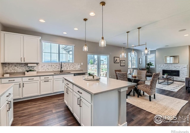 38 Morgan Cir S, Erie, CO 80516 - kitchen featuring a sink, dark wood-style flooring, decorative backsplash, white cabinets, and recessed lighting