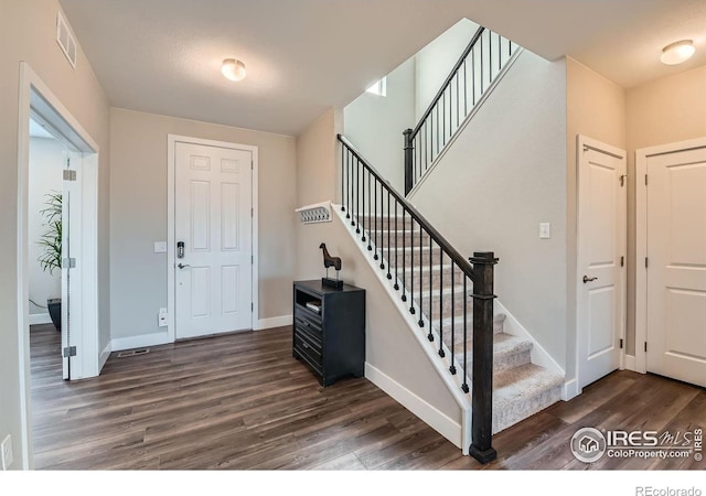 38 Morgan Cir S, Erie, CO 80516 - foyer entrance with dark wood finished floors, stairway, and baseboards