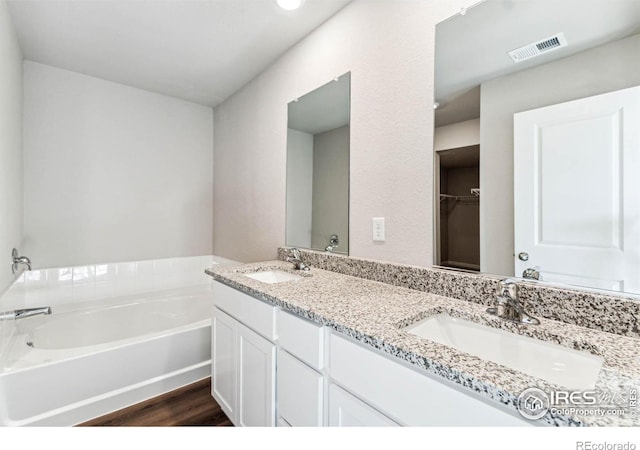 974 Cascade Falls St, Severance, CO 80550 - bathroom featuring double vanity, a garden tub, and wood finished floors