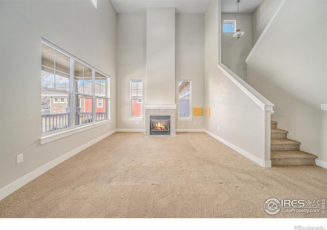 4751 Pleasant Oak Dr Unit C65, Fort Collins, CO 80525 - unfurnished living room with baseboards, carpet flooring, a towering ceiling, and stairs