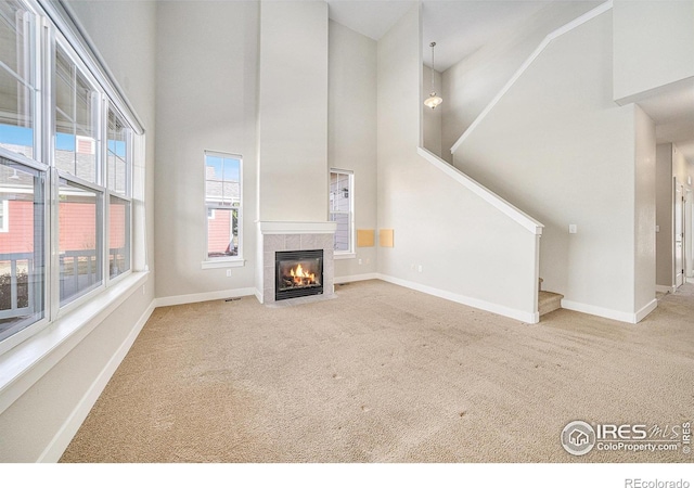 4751 Pleasant Oak Dr Unit C65, Fort Collins, CO 80525 - unfurnished living room with a high ceiling, carpet, baseboards, and a tiled fireplace