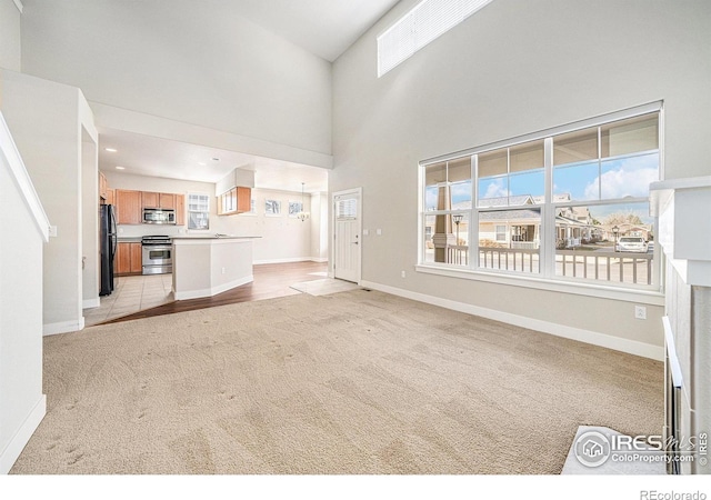 4751 Pleasant Oak Dr Unit C65, Fort Collins, CO 80525 - unfurnished living room with a towering ceiling, light carpet, baseboards, and recessed lighting