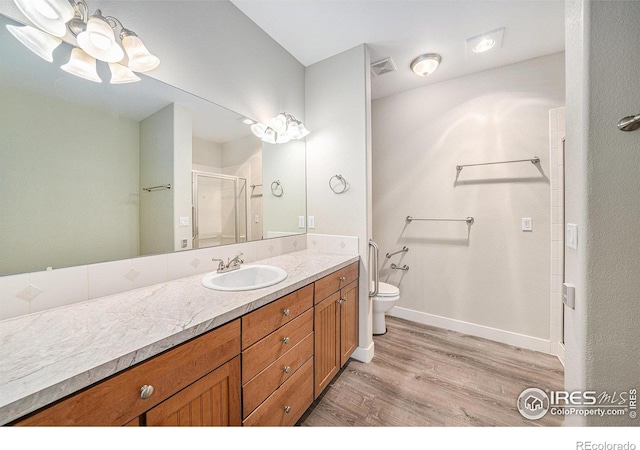 4751 Pleasant Oak Dr Unit C65, Fort Collins, CO 80525 - bathroom featuring vanity, toilet, a stall shower, visible vents, and wood finished floors