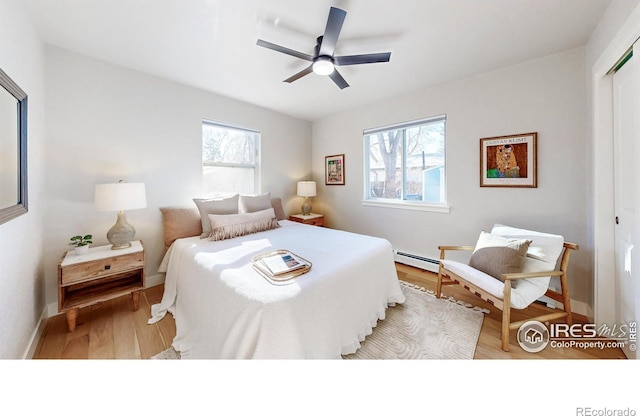 1325 11th Ave, Longmont, CO 80501 - bedroom featuring a baseboard heating unit, wood finished floors, baseboards, a closet, and a ceiling fan