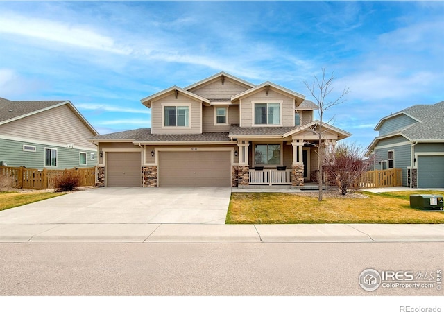 craftsman inspired home with a porch, driveway, a garage, and fence