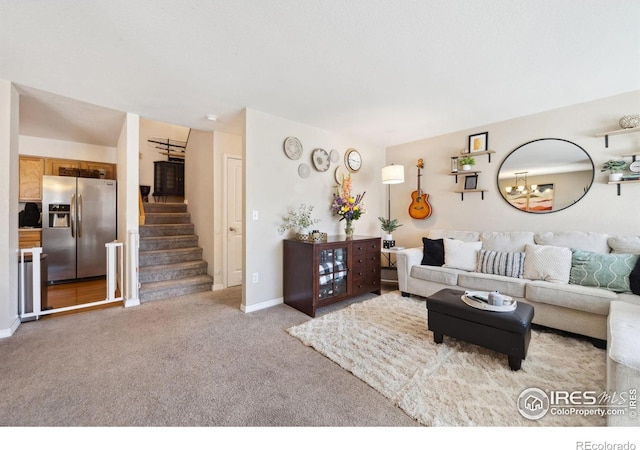 carpeted living room featuring a notable chandelier, baseboards, and stairway