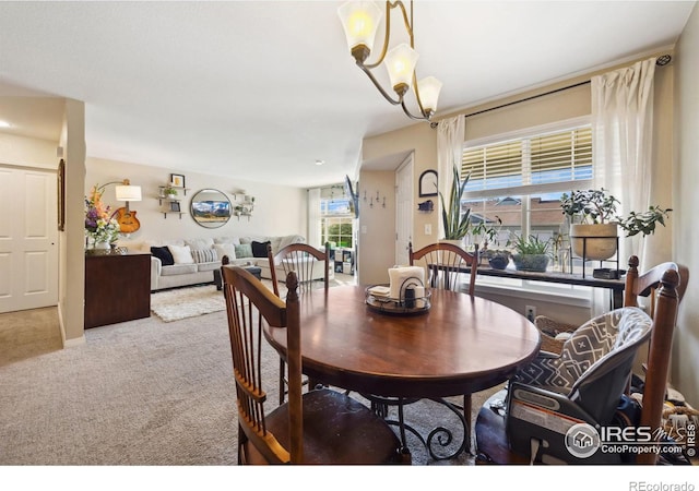carpeted dining room with a notable chandelier