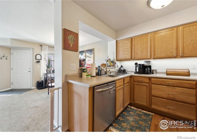 kitchen with light countertops, a sink, carpet floors, and stainless steel dishwasher