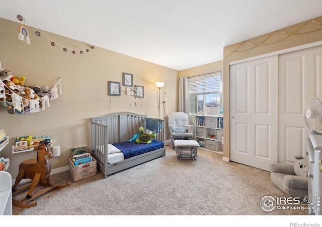 carpeted bedroom featuring baseboards and a closet