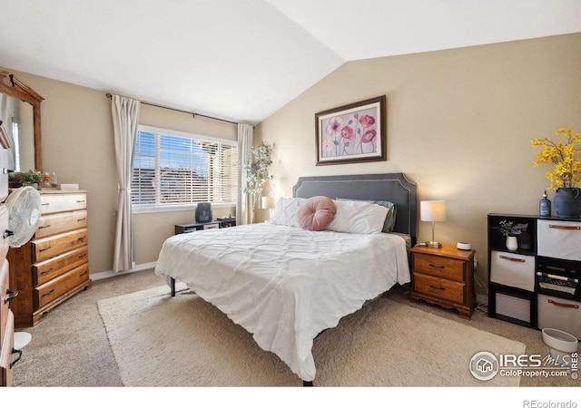 bedroom featuring baseboards, vaulted ceiling, and light carpet