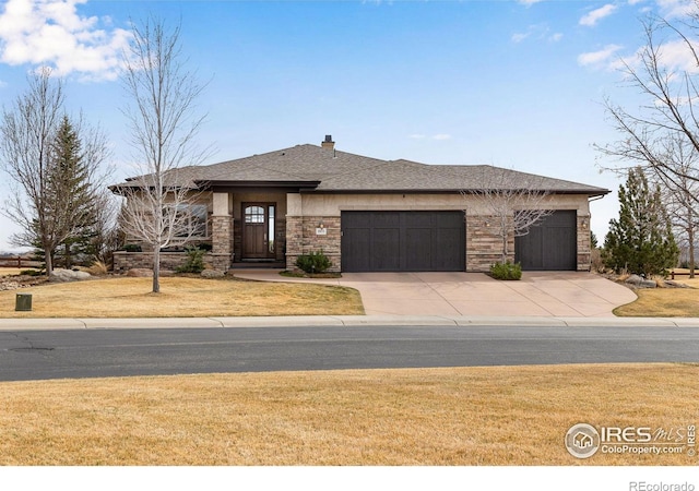 view of front facade with stone siding, a garage, concrete driveway, a front lawn, and a shingled roof