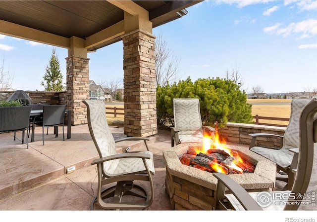 view of patio / terrace with an outdoor fire pit, outdoor dining space, and fence