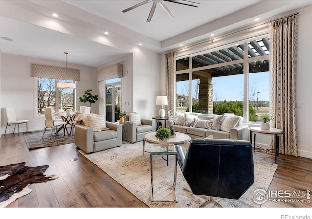 living area featuring baseboards, wood finished floors, recessed lighting, and a ceiling fan