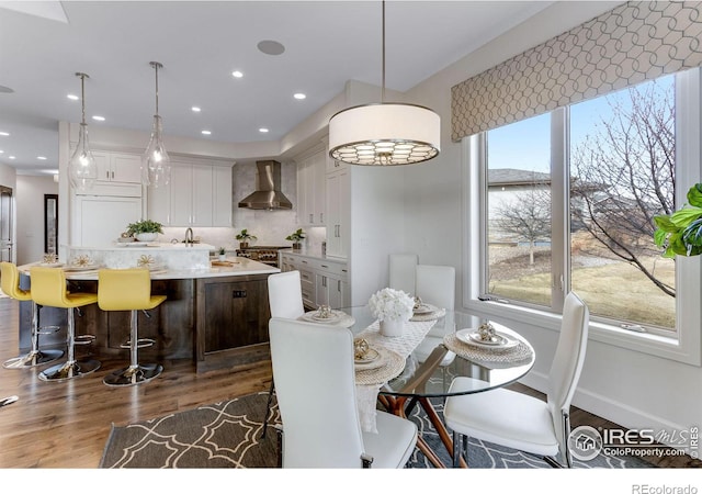dining area with dark wood-style flooring, baseboards, and recessed lighting