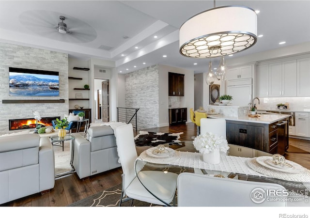 dining space featuring a fireplace, dark wood-style floors, recessed lighting, and a ceiling fan