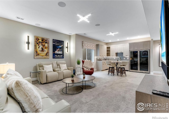 living area featuring baseboards, light colored carpet, and visible vents
