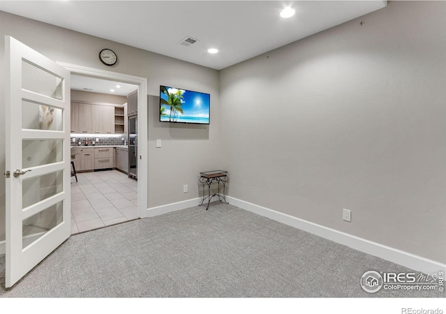 empty room with baseboards, visible vents, recessed lighting, and light colored carpet