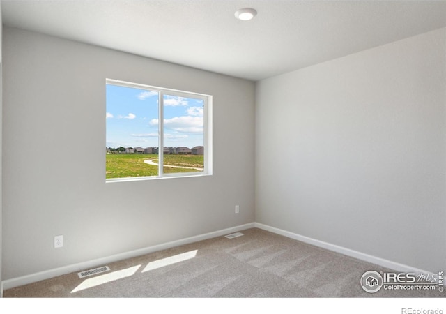carpeted empty room with baseboards and visible vents
