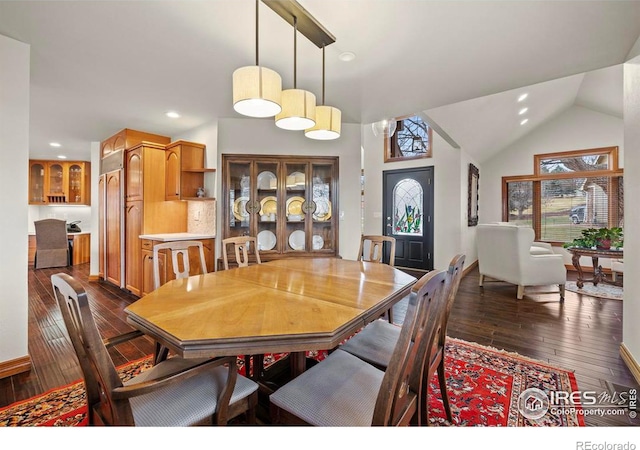 dining area featuring dark wood-style floors, vaulted ceiling, and recessed lighting