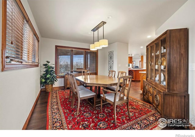 dining space featuring dark wood-type flooring, baseboards, and recessed lighting