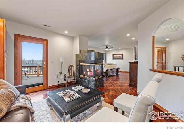 living area with a fireplace, recessed lighting, ceiling fan, and visible vents