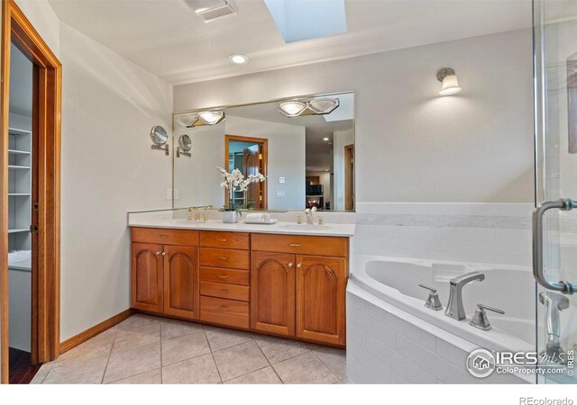 bathroom with tile patterned floors, a sink, a skylight, a garden tub, and double vanity