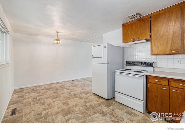 2 Lincoln Pl, Longmont, CO 80501 - kitchen with white appliances, stone finish floors, brown cabinetry, and backsplash
