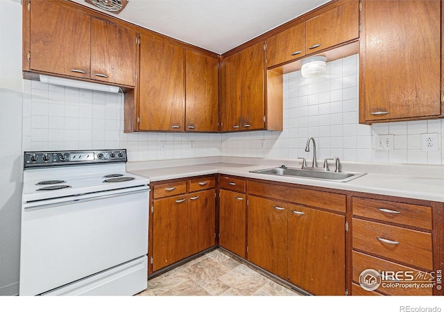 2 Lincoln Pl, Longmont, CO 80501 - kitchen with white electric range oven, a sink, brown cabinets, and decorative backsplash