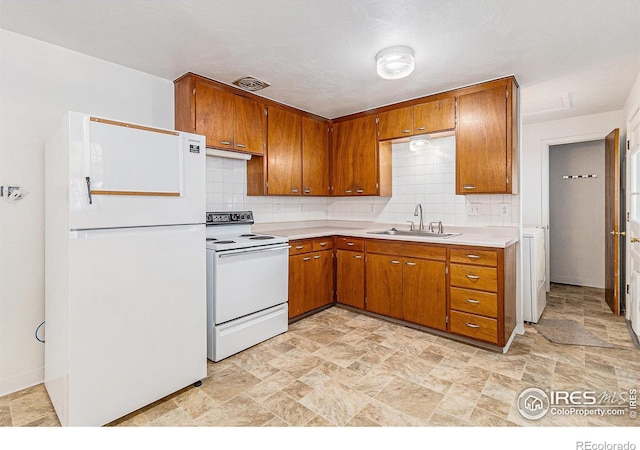 2 Lincoln Pl, Longmont, CO 80501 - kitchen with white appliances, a sink, brown cabinets, and stone finish flooring