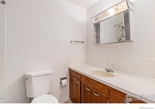 2 Lincoln Pl, Longmont, CO 80501 - bathroom with toilet, vanity, and decorative backsplash