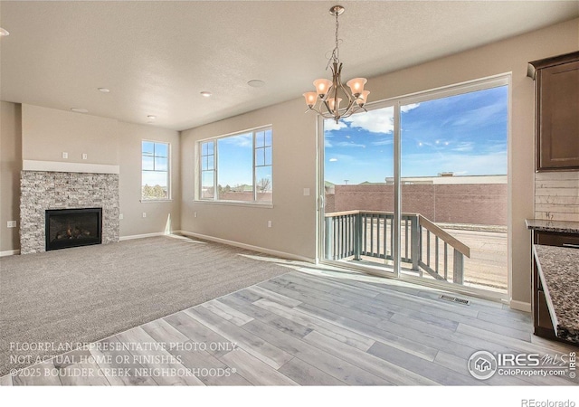 2387 Bristol St, Superior, CO 80027 - unfurnished living room featuring a stone fireplace, a chandelier, light wood-style floors, baseboards, and recessed lighting