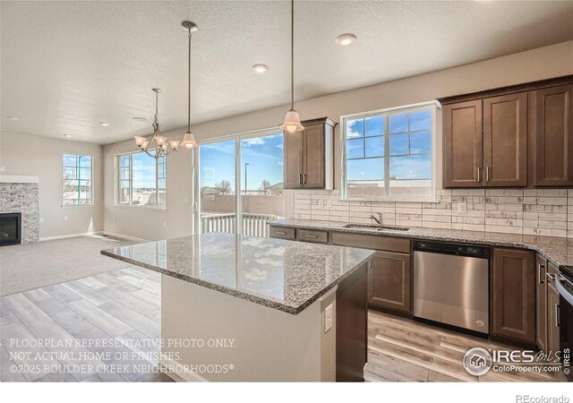 2387 Bristol St, Superior, CO 80027 - kitchen featuring stainless steel dishwasher, light wood-style floors, a sink, backsplash, and a textured ceiling