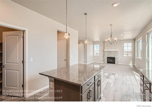 2387 Bristol St, Superior, CO 80027 - kitchen with baseboards, light wood finished floors, light stone counters, and pendant lighting