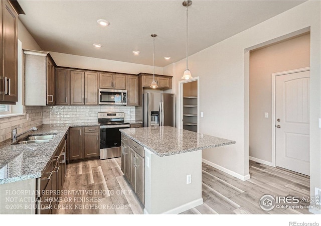 2387 Bristol St, Superior, CO 80027 - kitchen with appliances with stainless steel finishes, a sink, light wood-style floors, backsplash, and recessed lighting