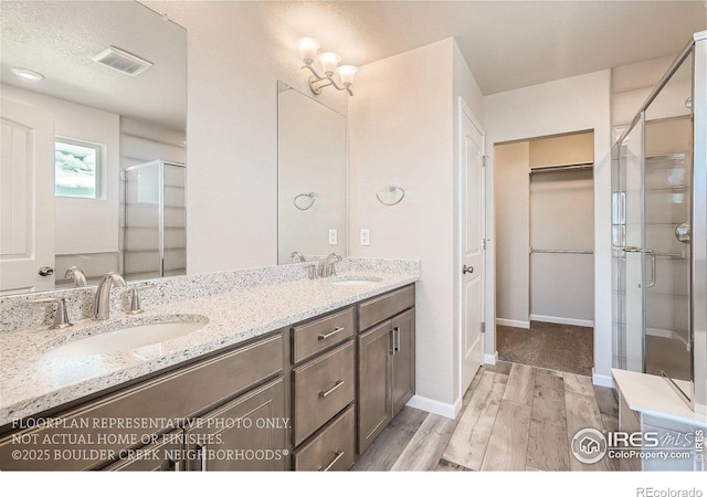 2387 Bristol St, Superior, CO 80027 - full bath with wood finished floors, a shower stall, double vanity, and baseboards