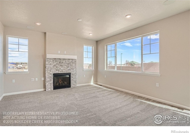 2387 Bristol St, Superior, CO 80027 - unfurnished living room with baseboards, a stone fireplace, recessed lighting, carpet flooring, and a textured ceiling