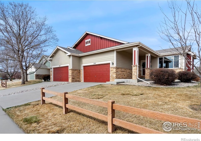2747 Dafina Dr, Loveland, CO 80537 - craftsman-style house with a garage, a front lawn, fence, stone siding, and board and batten siding