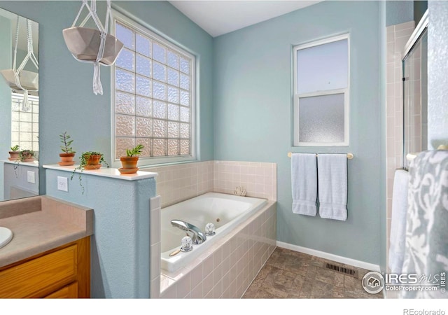 2747 Dafina Dr, Loveland, CO 80537 - full bathroom with visible vents, a shower with shower door, a tub with jets, baseboards, and vanity