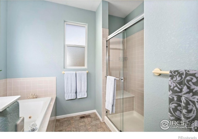 2747 Dafina Dr, Loveland, CO 80537 - full bath with baseboards, a whirlpool tub, a stall shower, and visible vents
