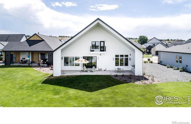 rear view of property featuring a patio and a lawn