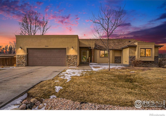 7889 Antelope Ct, Wellington, CO 80549 - view of front facade featuring stone siding, an attached garage, concrete driveway, and stucco siding