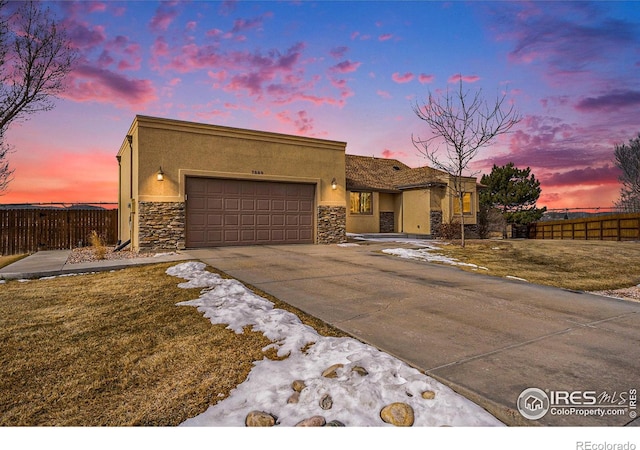 7889 Antelope Ct, Wellington, CO 80549 - view of front of home featuring fence, stucco siding, and an attached garage