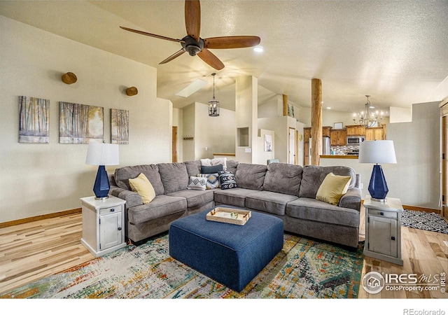 7889 Antelope Ct, Wellington, CO 80549 - living area with high vaulted ceiling, a textured ceiling, light wood-style flooring, baseboards, and ceiling fan with notable chandelier