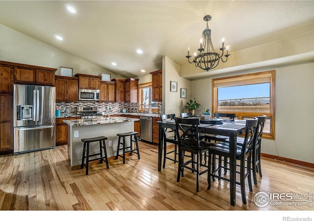 7889 Antelope Ct, Wellington, CO 80549 - dining area with baseboards, recessed lighting, lofted ceiling, light wood-type flooring, and a notable chandelier